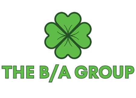 This is an image of "The B/A Group" logo. It has a line-line art representation of a green four-leaf clover centered over the words, "THE B/A GROUP," in all caps.